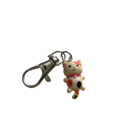 Mały breloczek z białym kotkiem i czarną kropką