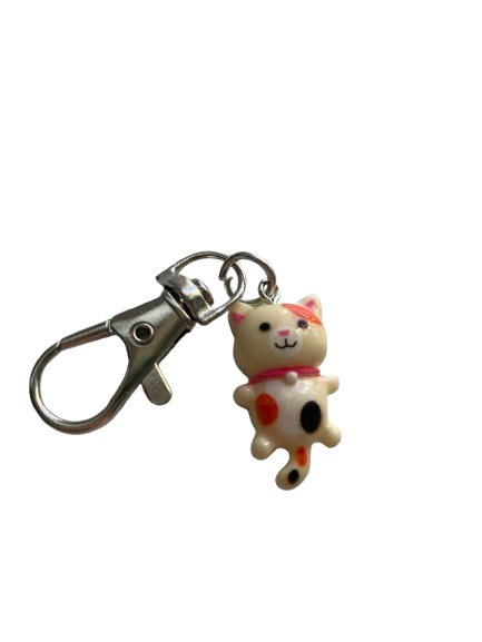 Mały breloczek z białym kotkiem i czarną kropką
